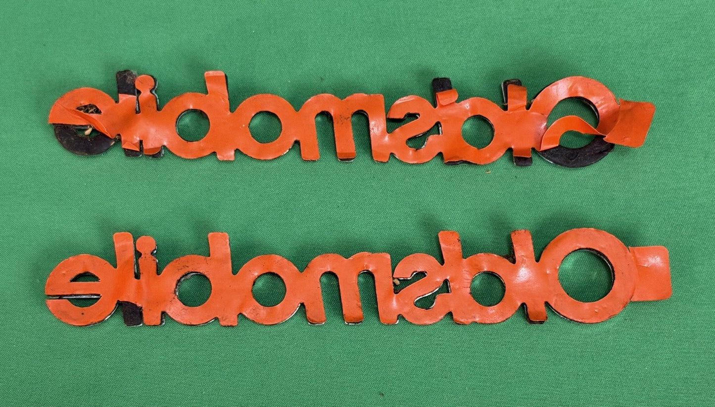NOS Oldsmobile Nameplate Emblem Adhesive Mount GM 20000969 / 555735–Bundle of 2