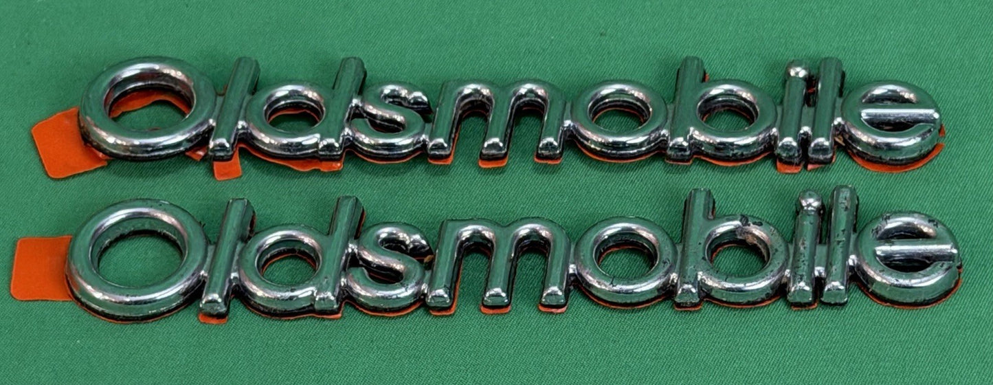 NOS Oldsmobile Nameplate Emblem Adhesive Mount GM 20000969 / 555735–Bundle of 2